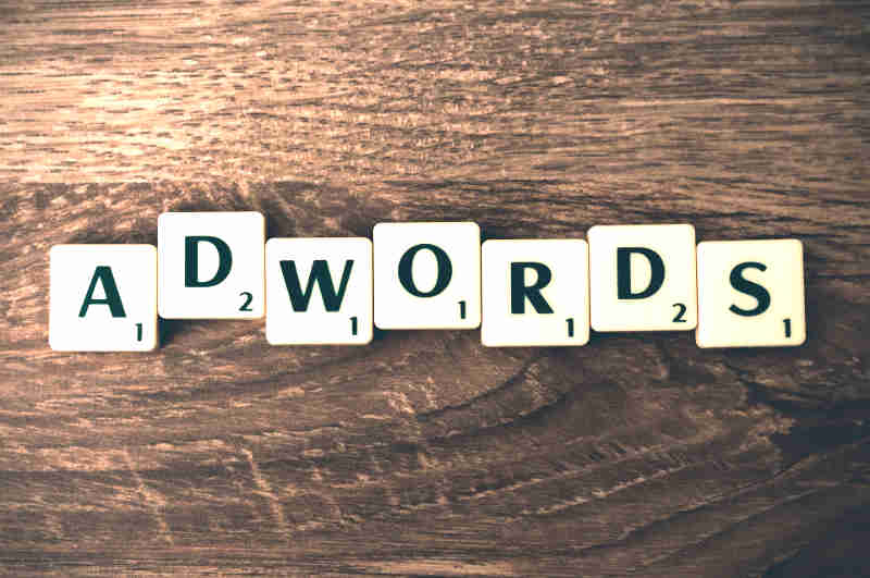 word adwords over wood grain background