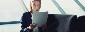 Slider image of a female sitting and reading documents